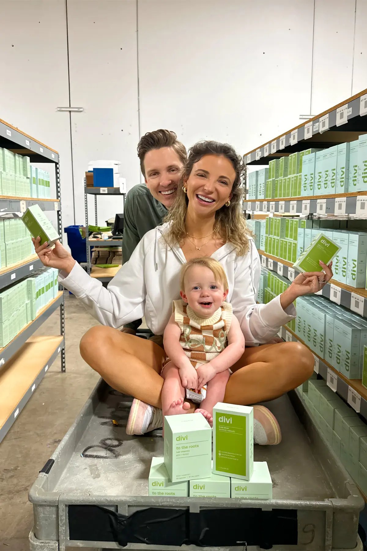 Dani Austin family sits on cart in Divi warehouse aisle.